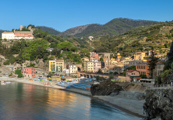 Fototapeta premium Scenic view of Monterosso al Mare, the famous village in Cinque Terre, Italy, featuring its golden sandy beach, crystal-clear Ligurian Sea, and colorful buildings along the rugged Italian Riviera