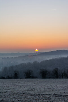 Winter landscape at sunrise with mist and frost
