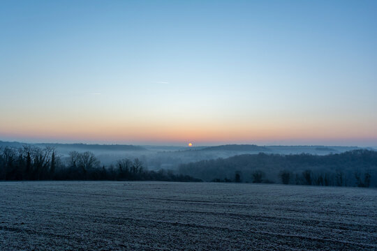 Winter landscape at sunrise with mist and frost