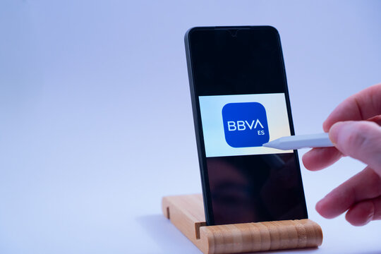 Hand interacts with bbva es banking app on a mobile phone display