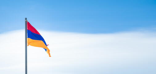 Armenian flag in the blue sky background.