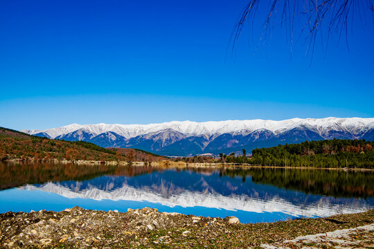 A magnificent geographical landscape photograph created by the spectacular reflection of the snow-covered slopes of Bursa Uludağ on the deep blue surface of G&ouml;k&ouml;z Lake.