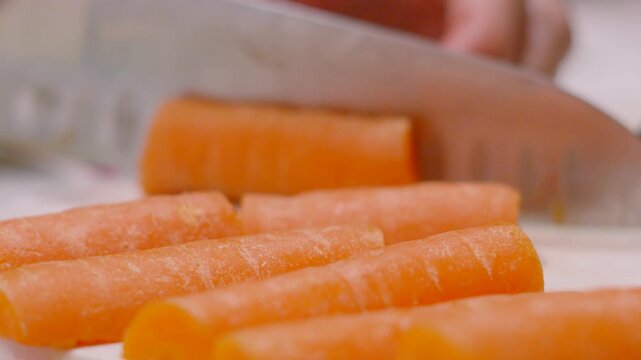 Carrot Being Chopped into Quarters and Placed with Other Vegetables Ready to Cook. Healthy Organic Fresh Plant Based Produce. High-quality food cinematography for cooking content.
