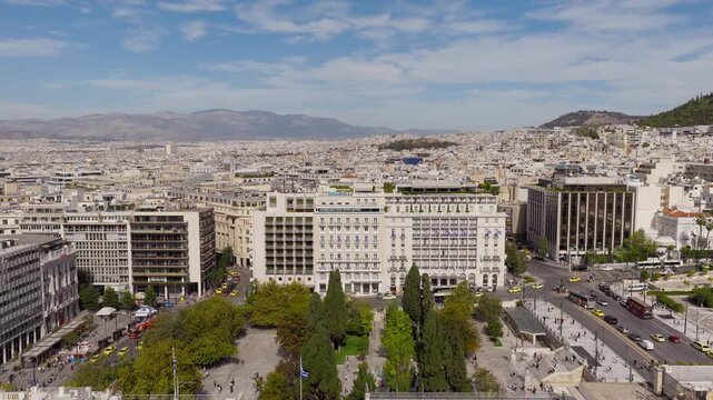 Aerial footage capturing the historic King George Hotel and Hotel Grande Bretagne at Syntagma Square under clear skies and soft clouds