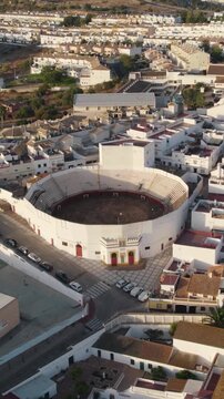 Vertical aerial view showcasing the Plaza de Toros bullring in Ayamonte, highlighting its Moorish-style architecture and circular design.