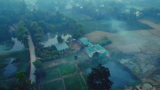 Aerial View of a Quiet Village with Morning Mist and Farmland