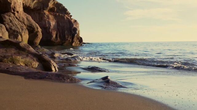 Slow Motion. Waves Splashing Over Rocks On Sandy Beach Shoreline 
