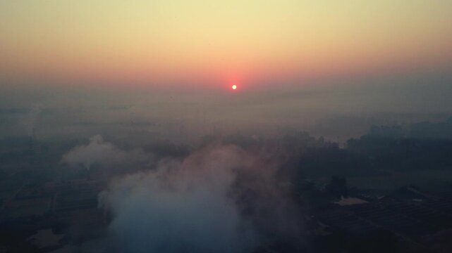 Cinematic Sunrise Over Foggy Landscape with Factory Emissions