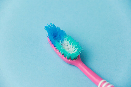 Old toothbrush close-up on blue paper background