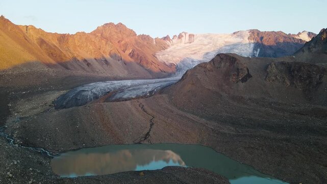 a beautiful ancient glacier. a moraine lake under the glacier. highlands