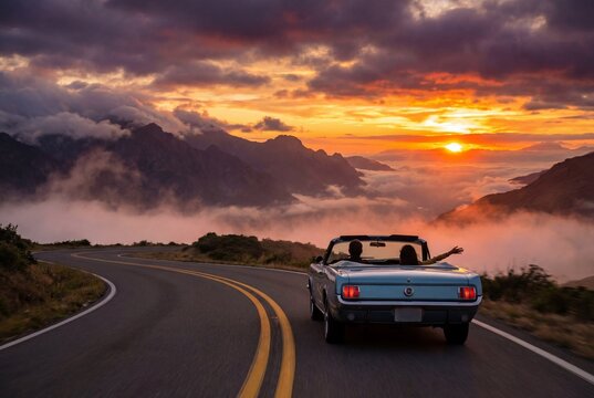 Couple driving vintage blue convertible on winding mountain road during sunset above clouds