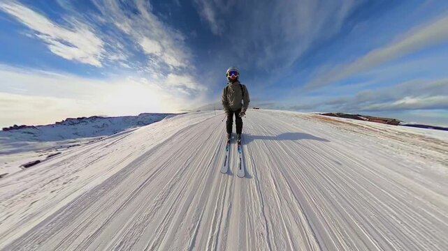 A wide-angle shot of skiers on a snow-covered slope at Alpe di Siusi in the Italian Dolomites. The vast, open landscape under a deep blue sky captures the solitude and grandeur of the Alpine mountains