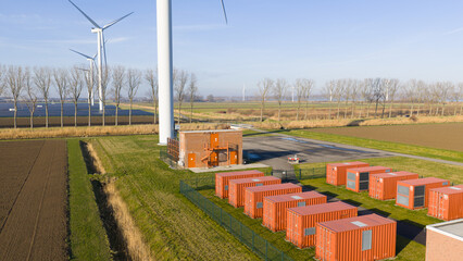 Obraz premium Wind turbines and battery storage facility distributing renewable energy