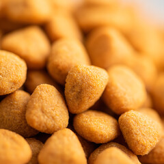 Close-up view of golden, triangular-shaped snack pieces piled together, showcasing texture and color