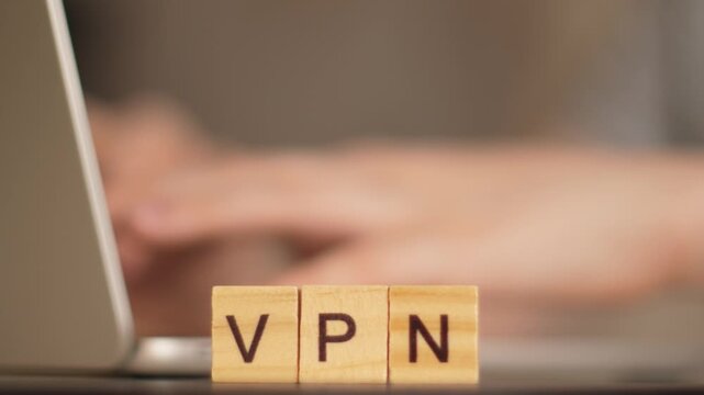 VPN concept for secure internet access: &ldquo;VPN&rdquo; word made of letters with a working laptop in the background
