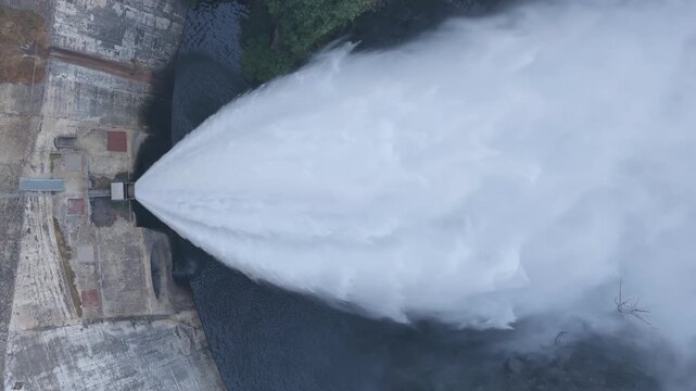 Aerial, dam with water jet and a street on it, Hydroelectric power plant, Presa de Almendra, Spain