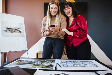 Two young women discussing architectural creativity and sharing ideas with enthusiasm