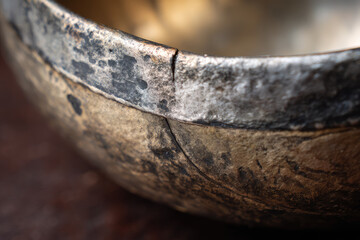 Fototapeta premium Thai brass cooking wok with aged patina and visible repair line showing traditional craftsmanship and rustic texture in close up detail