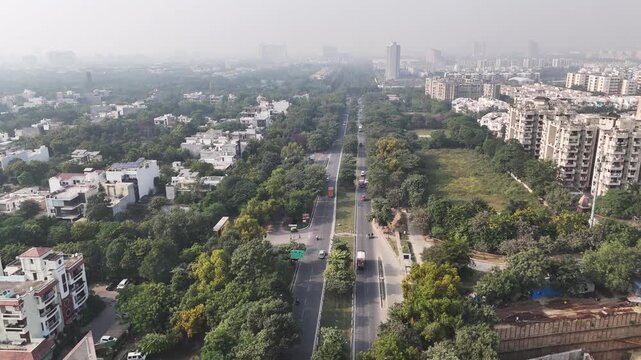 Wide aerial shot of Sector 36, RHO I, Greater Noida, capturing factories, institutional buildings, open plots, and structured urban planning under mild air pollution.