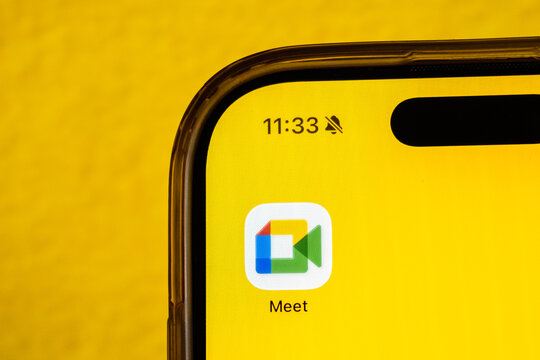 Cairo, Egypt - 27 01 2026: Mobile phone showing "Google Meet" icon on a yellow background. Social media icons on the digital screen of the phone