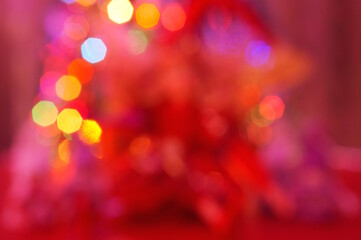 Obraz premium Blurred abstract Christmas background. Bokeh. Toys and glowing illumination. Red shade.