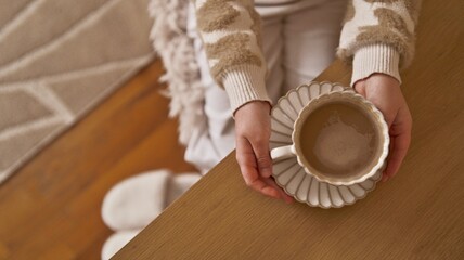 Cozy morning with a warm cup of coffee and soft slippers on a wooden table
