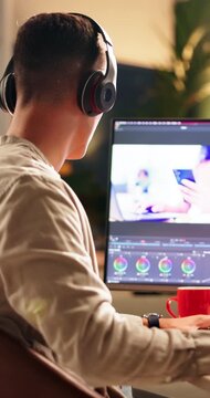Video editor, online and man with headphones, computer screen or creative for post production on web. Back, editing and person with tech for content creation, social media and process with software