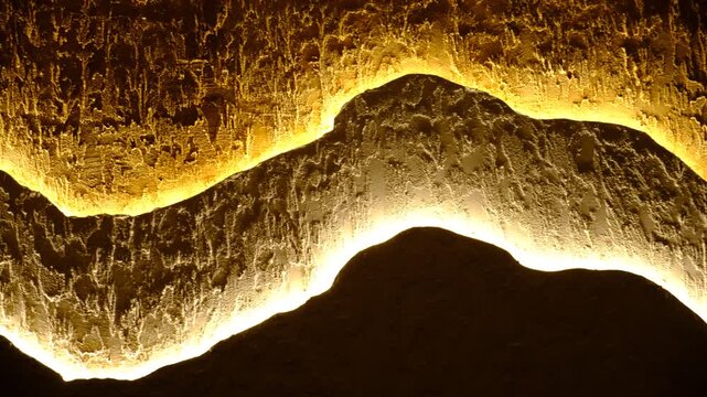 Modern apartment with three-layer wall , multilayer textured polymer mineral plaster, Abstract wavy curve panel wall, installed with hidden glowing led, provides illumination for fashion interior