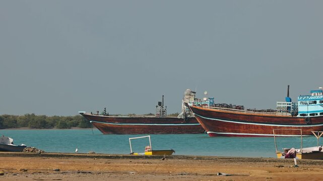 Traditional Dhow old wooden boat in the harbor of Iranian Qeshm Island. Tradition Lenj Fishing Boat in Qeshm Island in Southern Iran. Old wooden stealth smuggler's ship.