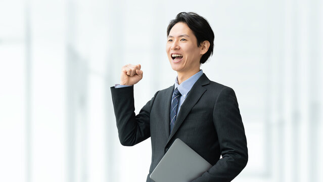 ガッツポーズで成果を喜ぶ日本人ビジネス男性, Japanese business man celebrating success with a fist pump