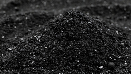 Activated charcoal particles forming dark textured mound, fine powder and small granules visible, black