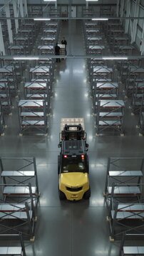 Male and woman workers discuss delivery load from a forklift with boxes in a large warehouse logistics center