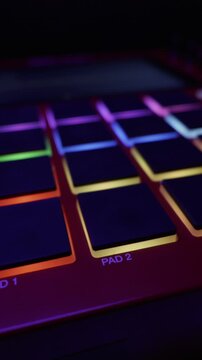 A smooth slider shot reveals the colorful illuminated pads of a modern music production controller. Concept of beat making, electronic sound design, and professional recording studio workflow.