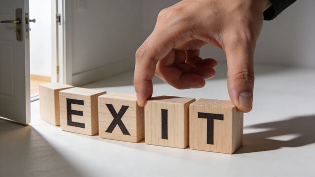 Hand placing wooden block spelling EXIT near an open door, concept