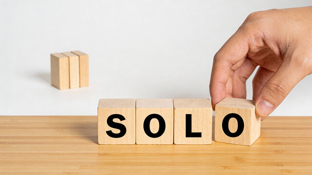 Hand Placing Wooden Blocks Spelling SOLO for Business Concept