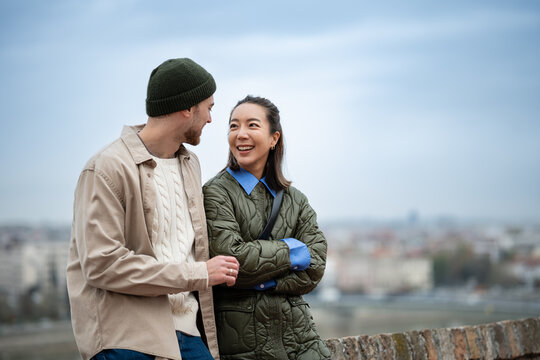 Smiling couple enjoying city view talking together