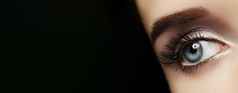 Closeup Blue Eye With Long Lashes, StudioLit Glamour Shot Showcasing Shimmer Eyeshadow, WellDefined Eyebrow, Crisp Skin Texture, Reflective Catchlight Creating Dramatic Mood, Makeup Model Showcasing