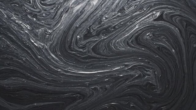 Swirling abstract pattern of black and gray lines creating a marbled, liquid, or cosmic effect