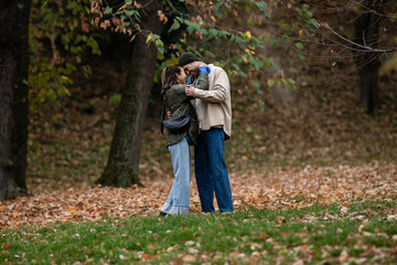 Young couple enjoying romantic fall walk in park