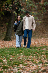 Obraz premium Couple walking and laughing in autumn park