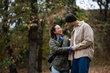 Fototapeta premium Interracial couple sharing happy moment in autumn park