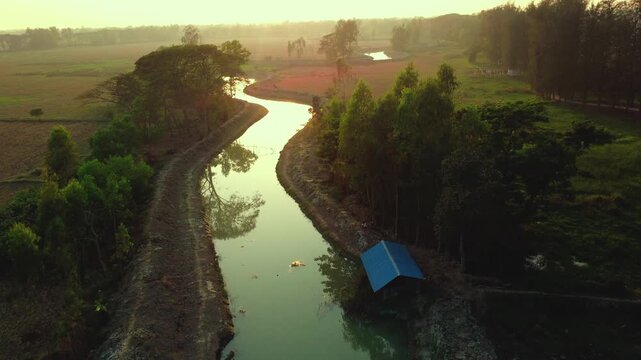 High-Angle Drone View of a Meandering Canal and Golden Fields at Sunset in Bangladesh 4k