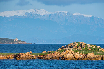 Vedetta militare e faro con le montagne innevate della Corsica