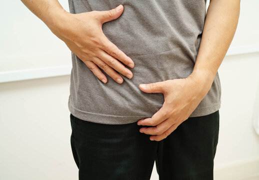 Hernia, Asian man stomach ache, abdominal pain and urology problem health.