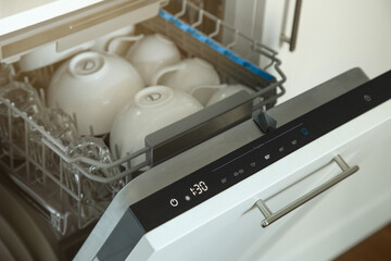 Open built-in dishwasher with clean dishes