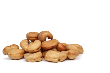 Obraz premium Unshelled roasted and salted cashew nuts on a white background