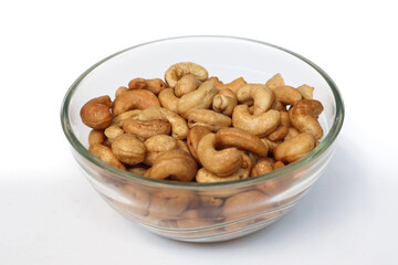 Fototapeta premium Cashews in a bowl. Roasted and salted cashews. A healthy snack. On a white background.
