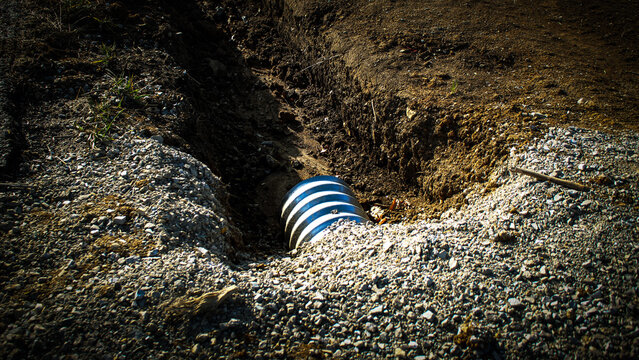 a culvert pipe installed in a trench, a drainage solution. engineering and construction concepts. erosion control design element.