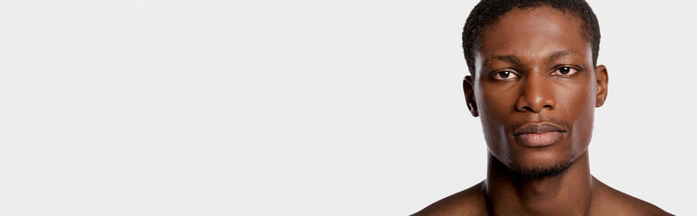 Fototapeta premium Handsome young man with a confident expression and striking features in a clean backdrop