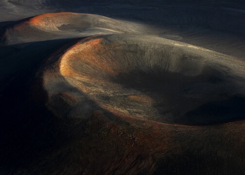 Aerial view of stark volcanic landscape with contrasting dark shadows and fiery orange hues, Hverir geothermal area, Myvatn, Thingeyjarsveit, Iceland.